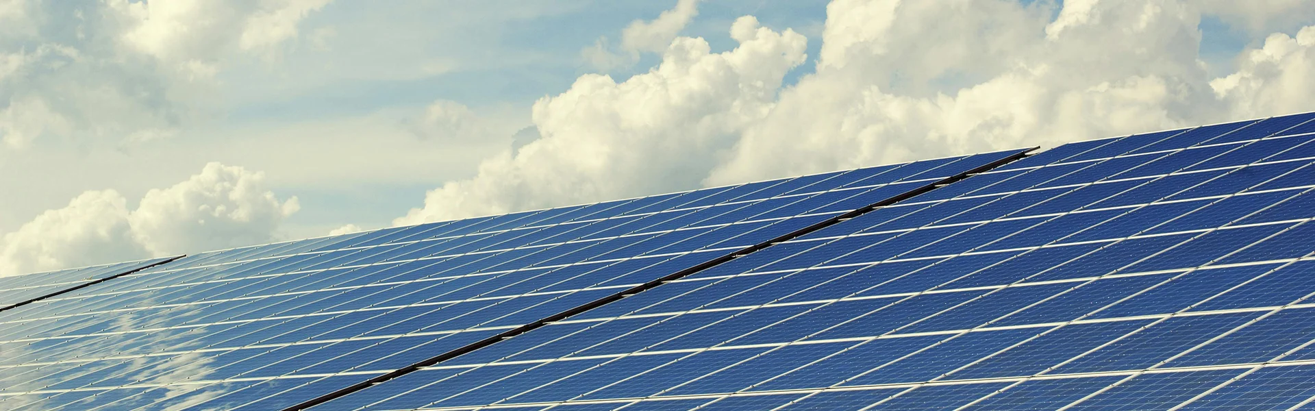Viele Solarpanele bei gutem Wetter vor blauem Himmel